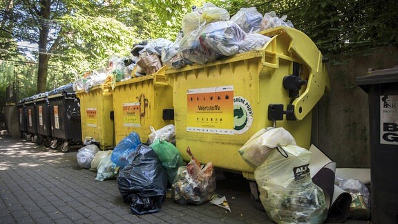 Überfüllte Müllcontainer stehen an einer Sammelstelle in Berlin.