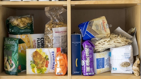 Verschiedene Lebensmittel werden in stabilen, verschlossenen Gefäßen und Dosen im Vorratsschrank einer Küche aufbewahrt