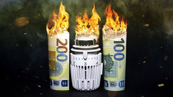 Symbolfoto Gaskosten - Heizungsthermostat zwischen brennenden Euroscheinen
