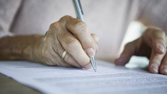 Seniorin unterzeichnet Dokument