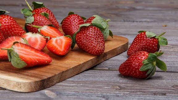 Erdbeeren liegen auf einem Brettchen.