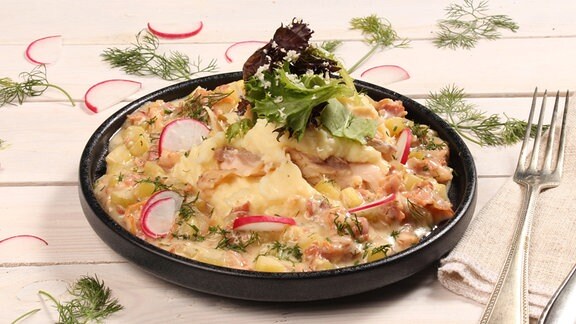 Ein Fisch-Gericht mit Kartoffelpüree, Salat und Radieschen