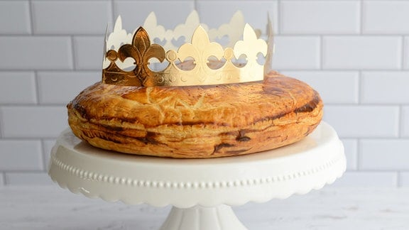 Ein runder Kuchen mit einer Krone aus Pappe.