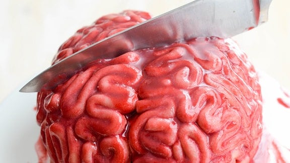Ein Messer steckt in einem Kuchen, der aussieht wie ein Gehirn.
