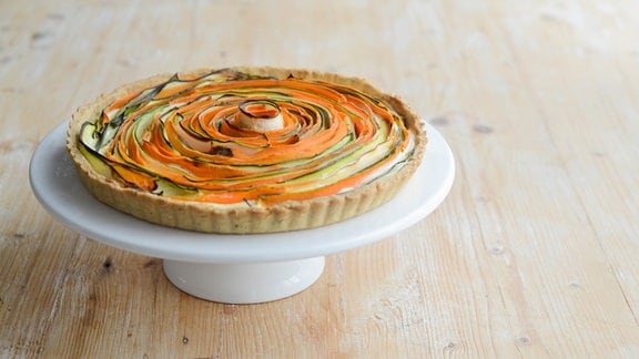 Eine Tarte mit bunten Gemüsestreifen.