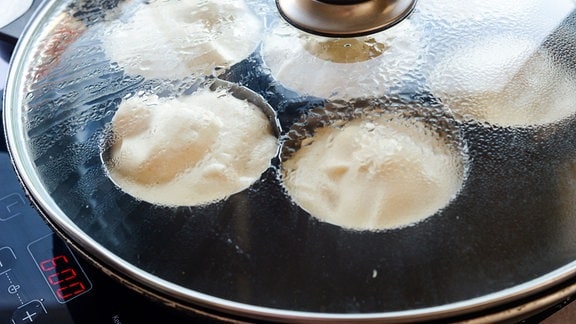 Teiggefüllte Pfannkuchennäpfchen in geschlossenener Pfanne