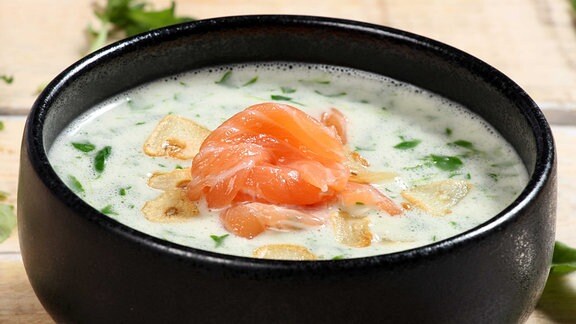 Eine helle Suppe mit Fisch garniert