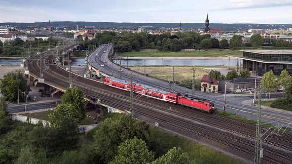 Eine S-Bahn zwischen den Bahnhöfen Dresden-Neustadt und Hauptbahnhof. Der Zug hat gerade die Elbe überquert. Am rechten Bildrand ein Teil des sächsischen Parlamentsgebäudes. S-Bahn in Dresden.