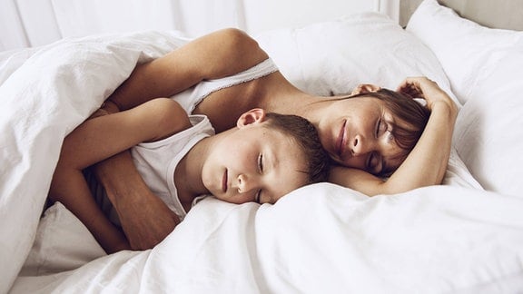 Mutter und Sohn schlafen im Bett