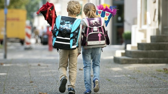 Zwei Schulanfänger mit Zuckertüte und Ranzen unterwegs.