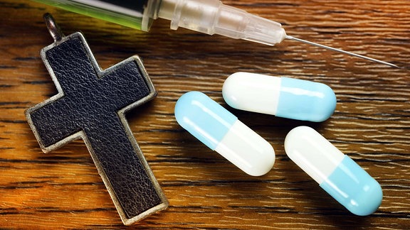 Kreuz, Tabletten und Spritze, Symbolfoto Sterbehilfe