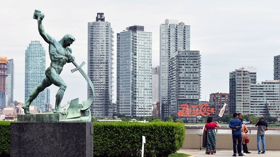 Die Statue «Let us beat swords into ploughshares (Schwerter zu Pflugscharen)» des Künstlers Jewgeni Vuchetich steht vor der Kulisse des East River und den Hochhäusern von Long Island City. 