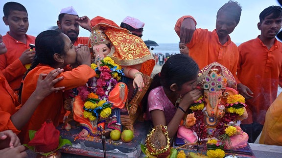 Ein Freiwilliger trägt ein Idol des Hindu-Gottes Ganesha zum Eintauchen in das Arabische Meer am fünften Tag und Gauri Ganapti des Ganesh Chaturthi Festivals am Juhu Beach.