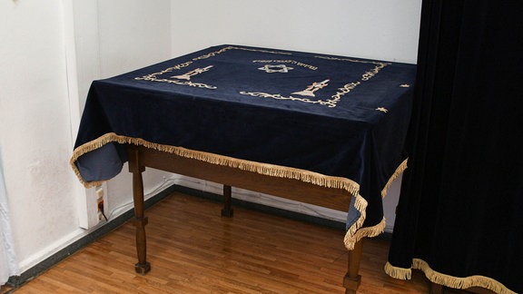 Ein Holztisch mit einer blauen Samtdecke