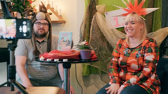 Ein Mann und eine Frau drehen ein Video weihnachtlich geschmückt