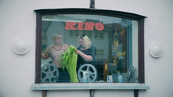 Zwei Frauen sind durch ein Fenster in einem Kino zu sehen