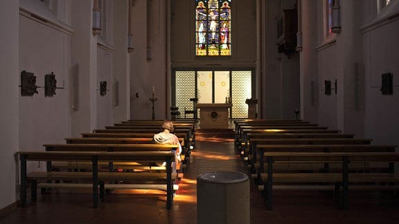 Eine Frau alleine in einer Kirche