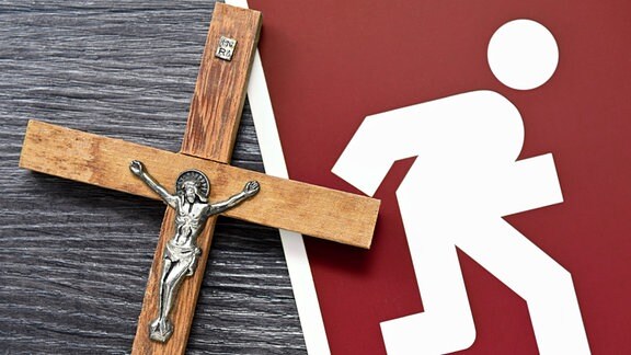 Symbolfoto Kirchenaustritte - Kreuz und Notausgangsschild