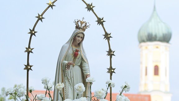Gläubige tragen bei der Wallfahrtskirche Maria Vesperbild bei der Lichterprozession eine Marienstatue