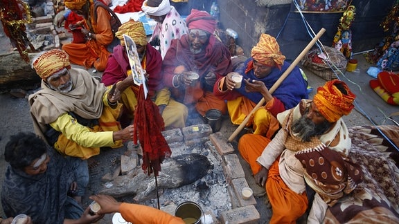 Sadhus oder heilige Männer sitzen nahe einem Feuer während Maha Shivaratri-Festivals an der Pashupatinath-Tempelprämisse in Kathmandu.