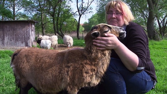 Eine Frau streichelt ein Schaf