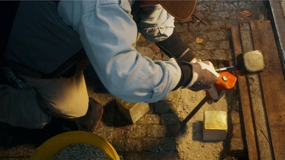 Gunter Deming verlegt vor dem ehemaligen Kaufhaus Totschek für die Familie Stolpersteine