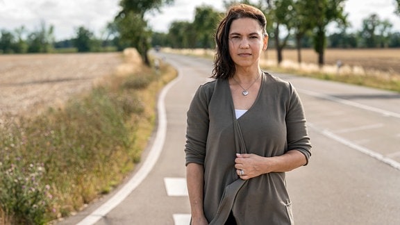 Eine Frau (Patrizia Bozinosk) steht an einer Landstraße.