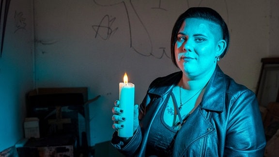 Frau (Natascha Horak) mit einer Kerze.