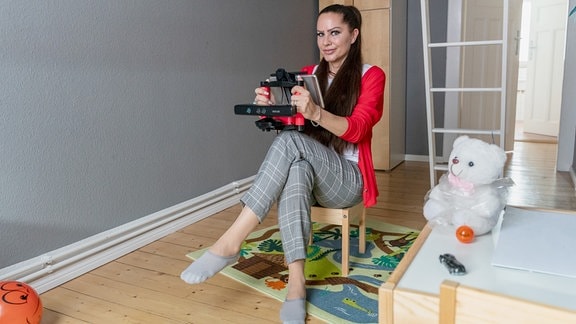 Eine Frau (Geisterjägerin Minckee) mit Tabletgerät in einem Raum