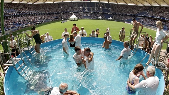 Teilnehmer eines Sonderkongresses der Zeugen Jehovas lassen sich in der AOL Arena in Hamburg bei einer Massentaufe taufen.