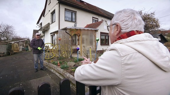 Reporter Andreas Neugeboren spricht mit einem Mann der vor seinem Haus steht.