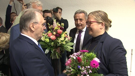 Datenschutzbeauftragte mit Blumenstrauß, während Ministerpräsident Haseloff gratuliert.