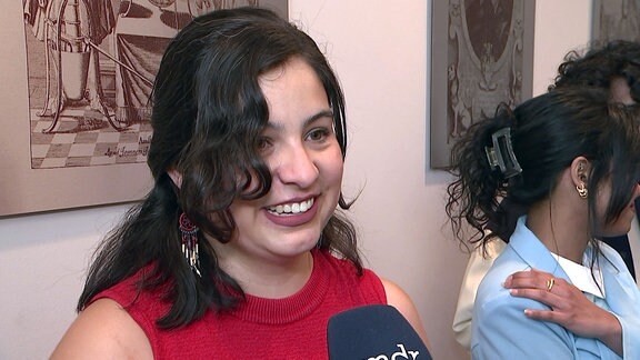 Eine junge Studentin lächelt während eines Interviews.