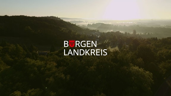 Schriftzug Burgenlandkreis, Hintergrund Blick auf eine waldige Naturlandschaft.