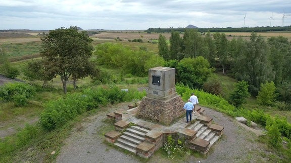 Zwei Männer stehen an einem Denkmal, Eisern Rothenburg