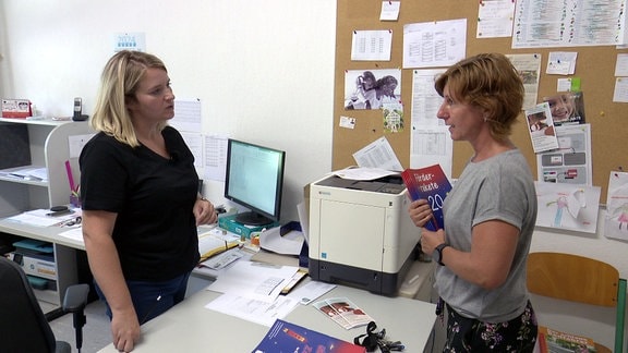 Schulverwaltungsassistentin im Gespräch im Büro.