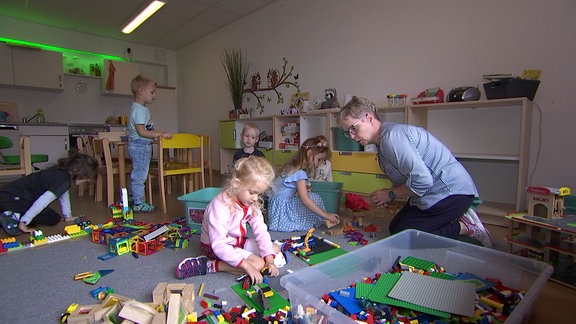 Erzieherin spielt mit Kindern.