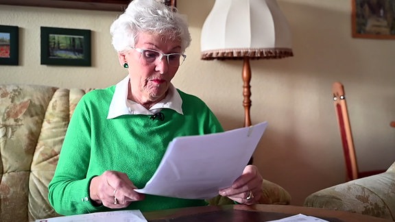 Rentnerin studiert ungläubig ihren neuen Kabelvertrag