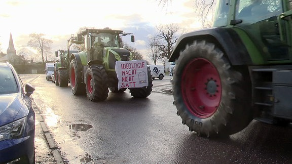 Bauern fahren für eine Demonstration in Treckern Kolonne.