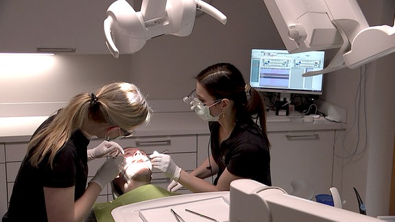 Zwei Zahnmedizinerinnen am Patienten