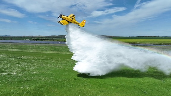 Ein Löschflugzeug wirft in einer Übung Wasser ab.