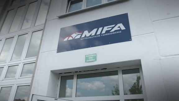 Ein Logo von MIFA hängt über einem Eingang.