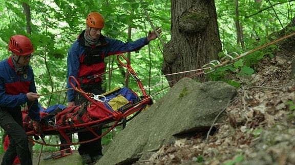 Die Bergrettung im Einsatz mit einer Trage an Seilen.