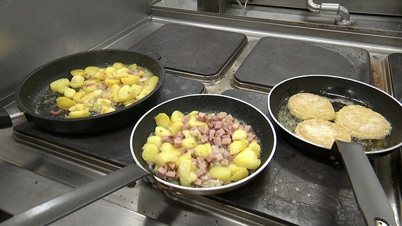 Drei Pfannen mit Kartoffelgerichten