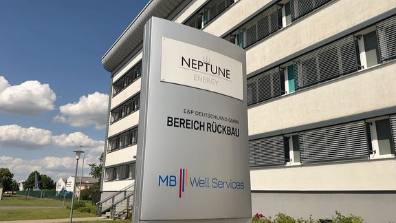 Säule mit Schild von der Firma Neptune vor ihrem Geschäftsgebäude