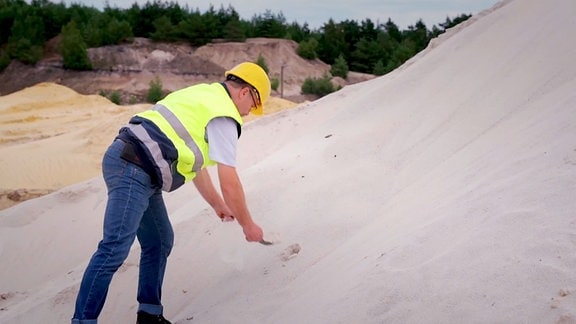 Betriebsleiter Hennry Löwe nimmt eine Sandprobe