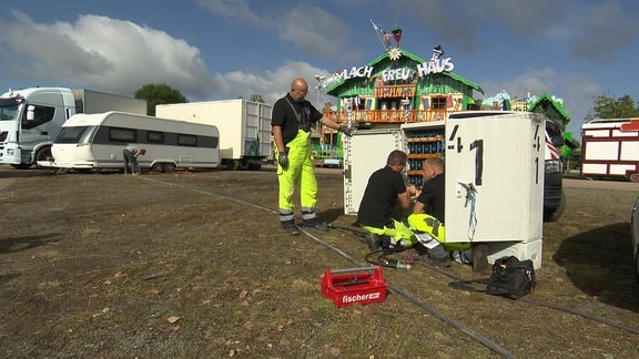 Techniker an einem Trafokasten