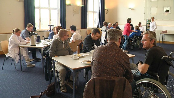 Menschen mit und ohne Rollstuhl bei einem Treffen