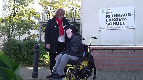 Rollstuhlfahrer Pascal und seine Mitter vor der Reinhard Lakomy Förderschule