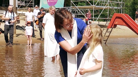 Menschen lassen sich im Heidesee taufen
